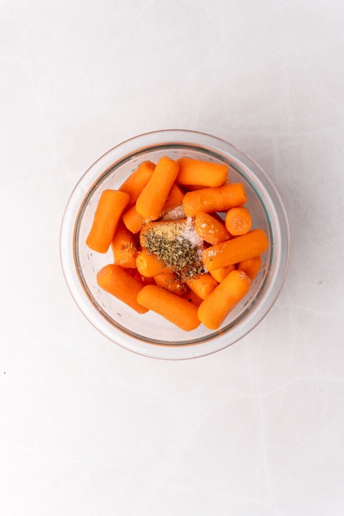 raw carrots in bowl with seasonings