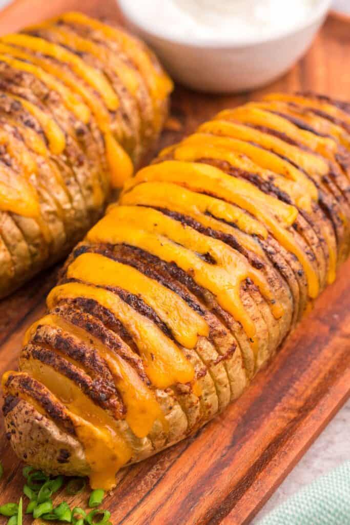 Close up of cooked air fryer hasselback potatoes with melted cheese.