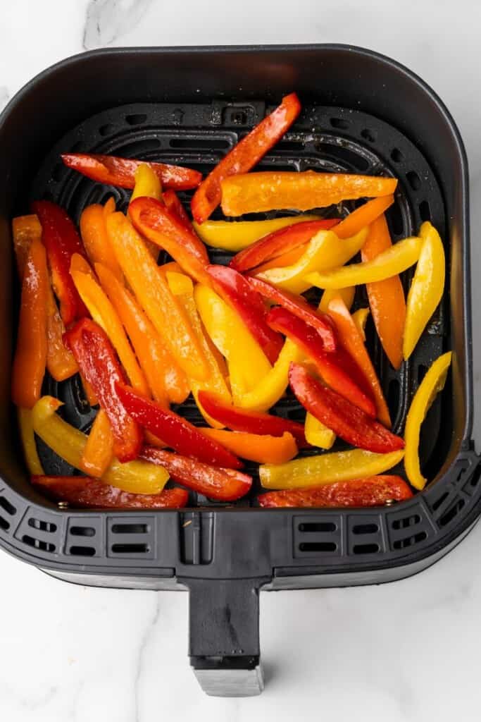 raw bell peppers in an air fryer basket