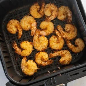 air fryer basket with cooked shrimp