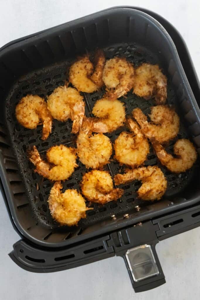 air fryer basket with cooked shrimp