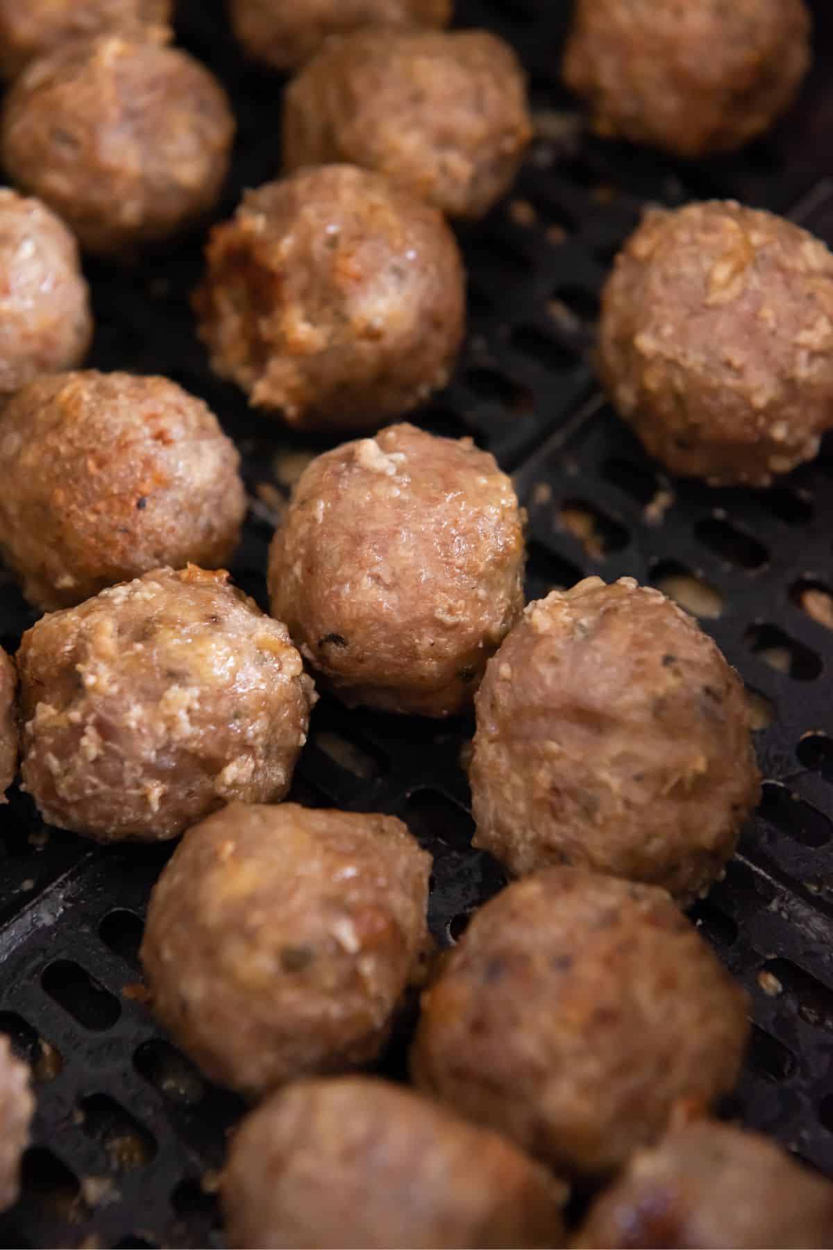 Close up of turkey meatballs in the air fryer basket.