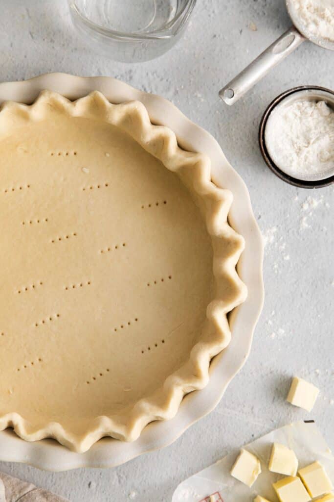 3 ingredient pie crust in a pie pan with crimped sides and fork holes on the bottom.