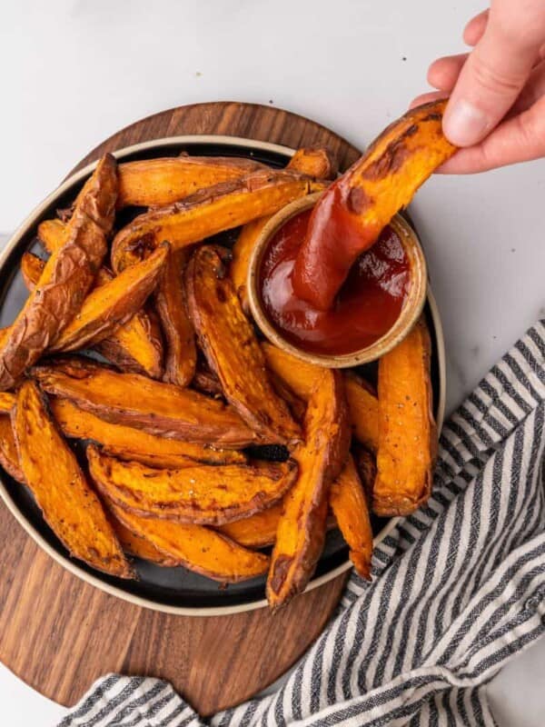 dipping sweet potato wedge into ketchup