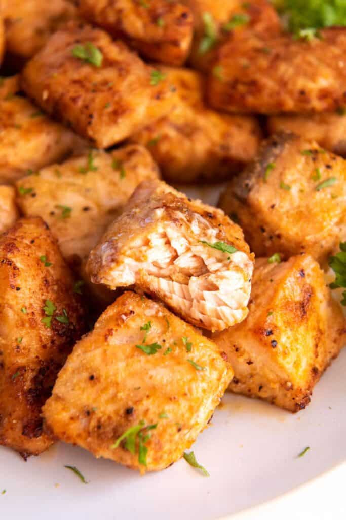Close up of air fry salmon bites with a bite taken out of one.