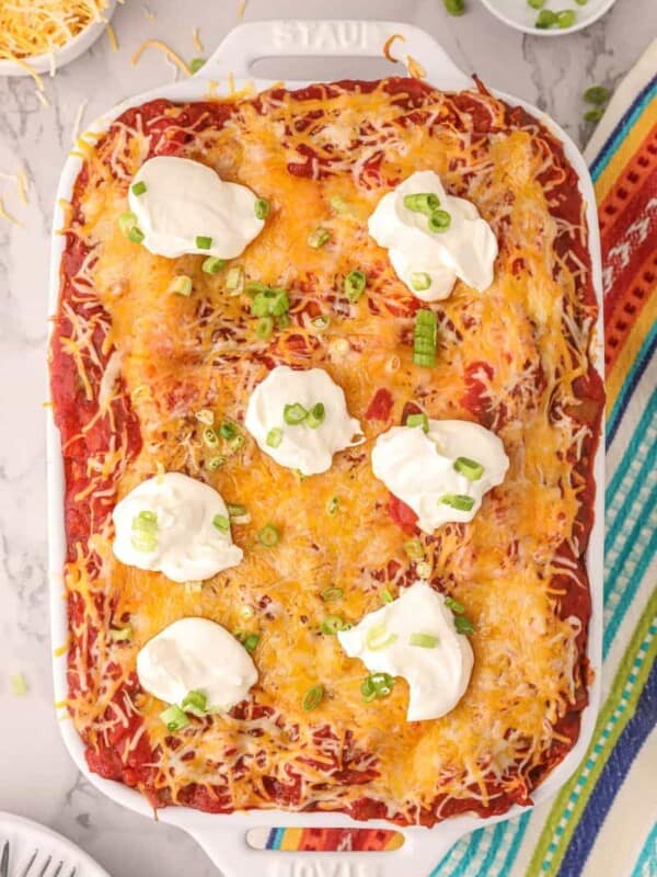 overhead view of the taco lasagna with sour cream dollops and green onions on top