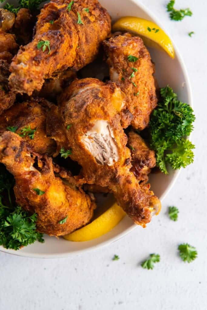 air fried chicken on plate with a bite taken out of a drumstick