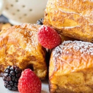 several pieces of hawaiian french toast rolls on a plate with fresh berries