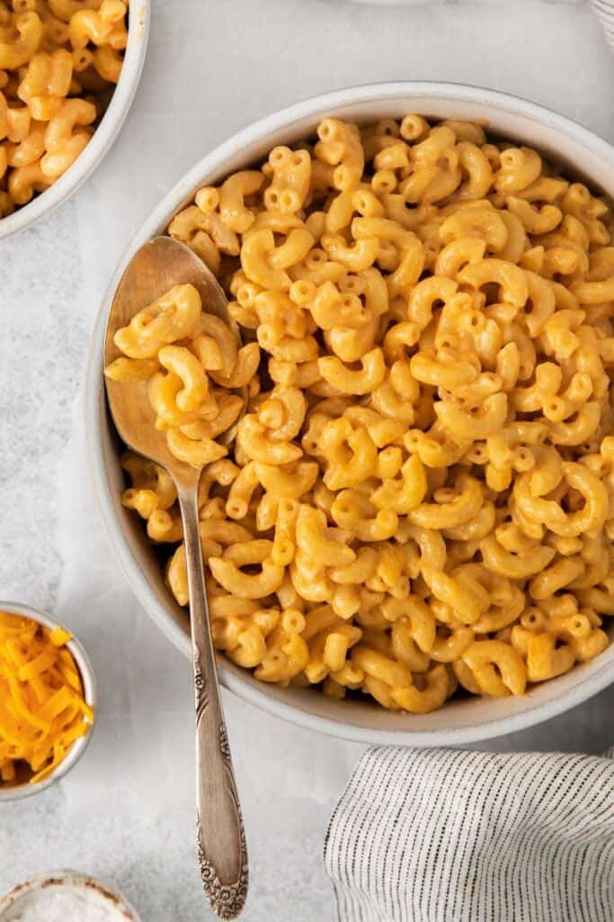 Mac and cheese without milk in a bowl with a spoon in the bowl.