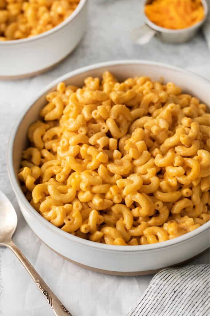 Mac and cheese without milk in a bowl with a spoon on the side.