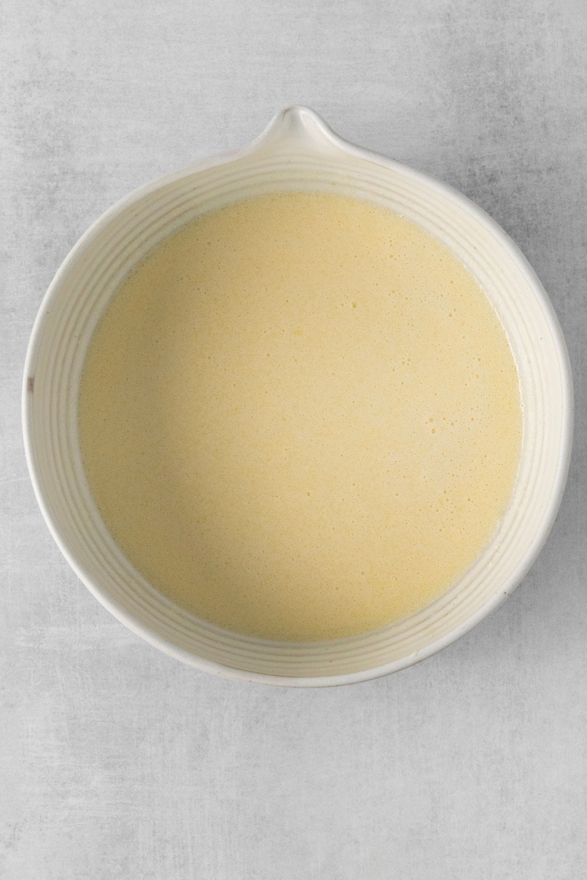 Wet ingredients mixed into a mixing bowl to make pancakes.