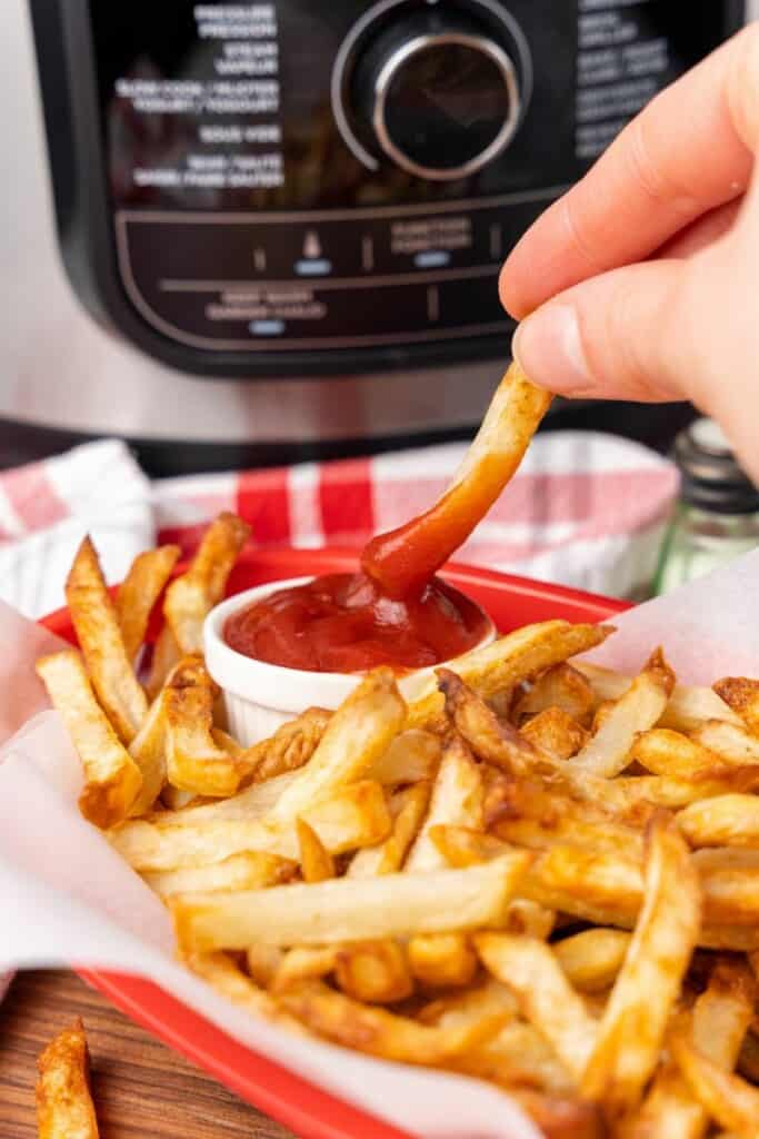 dipping fry into ketchup
