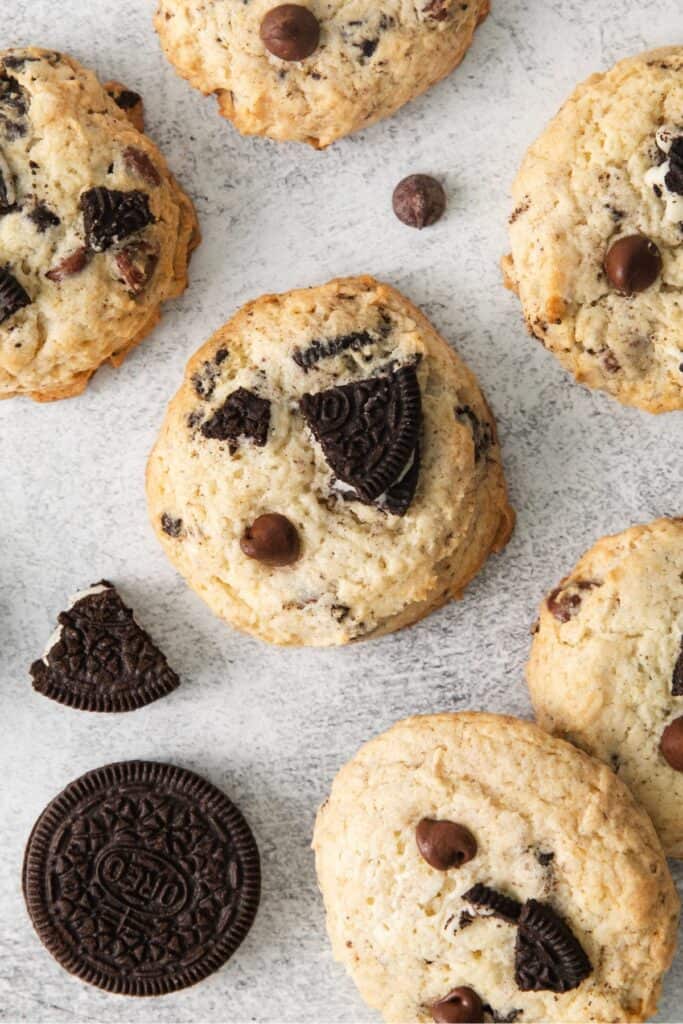 Close up of Oreo cheesecake cookies on parchment paper next to an Oreo.
