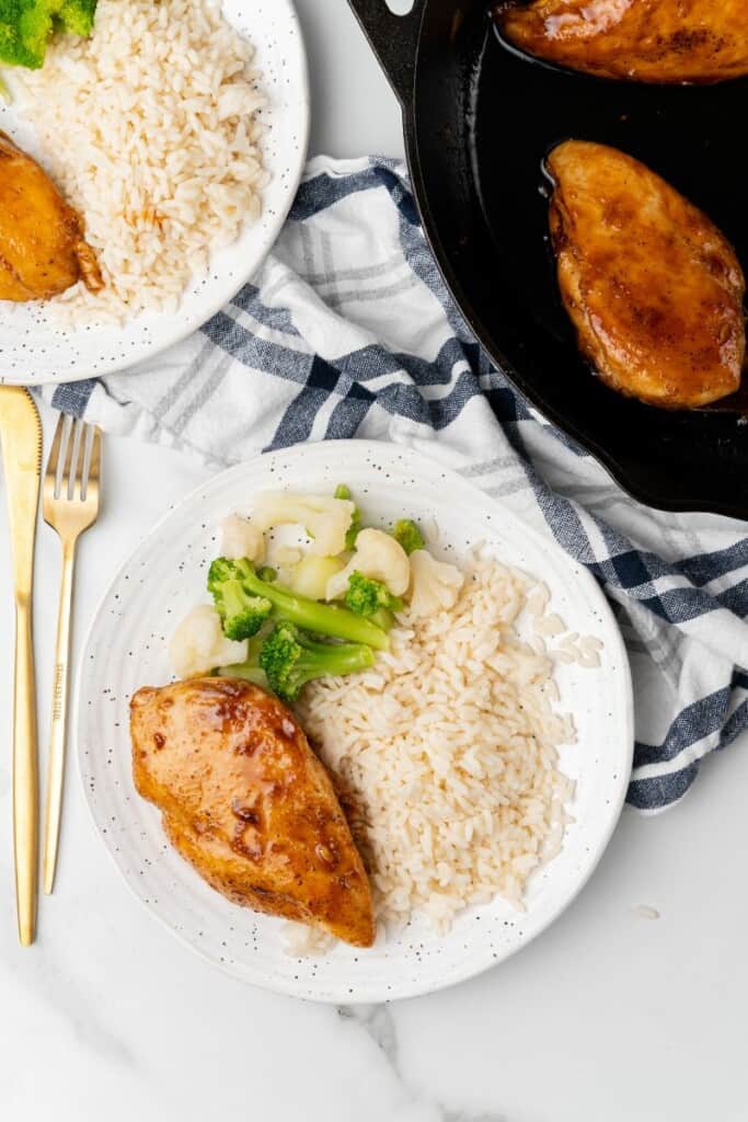 Overhead view of Chicken Breast rice, broccoli, and cauliflower on a white plate.
