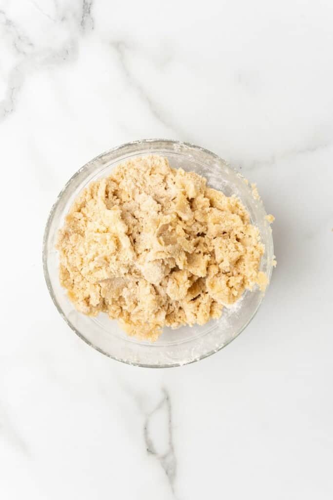 Overhead view of wet and dry ingredients for crockpot french toast casserole mixed together in a clear bowl.