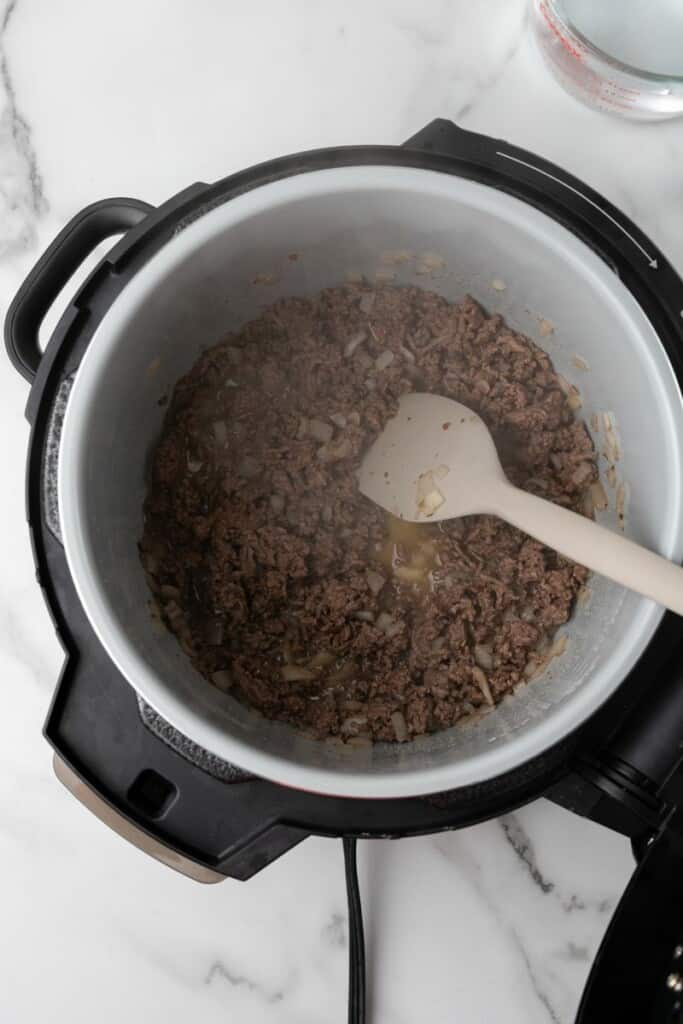 Overhead view of ground beef browning in a Ninja Foodi.