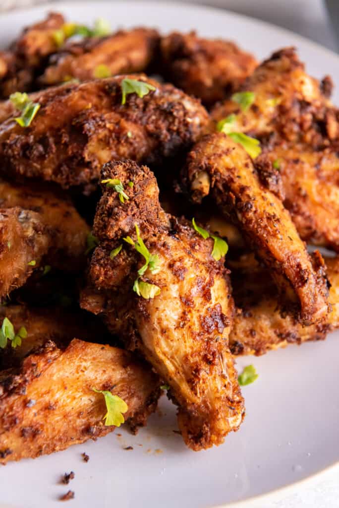 Side view of chicken wings prepared in the air fryer on a white plate.
