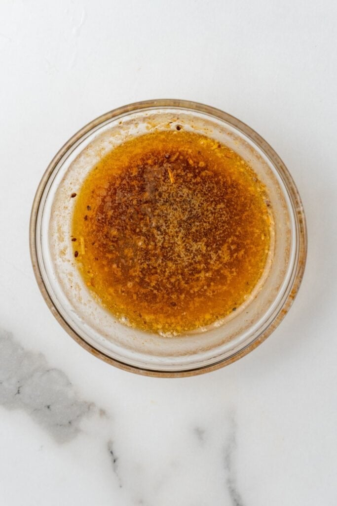 Melted butter and Cajun seasoning in a small bowl.
