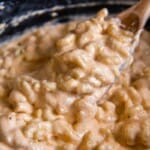 Overhead view of a spoon holding a bite of slow cooked macaroni and cheese.
