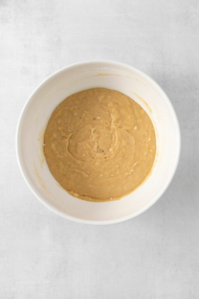 Combing mashed banana, butter, brown sugar, egg yolks, and vanilla in a mixing bowl.
