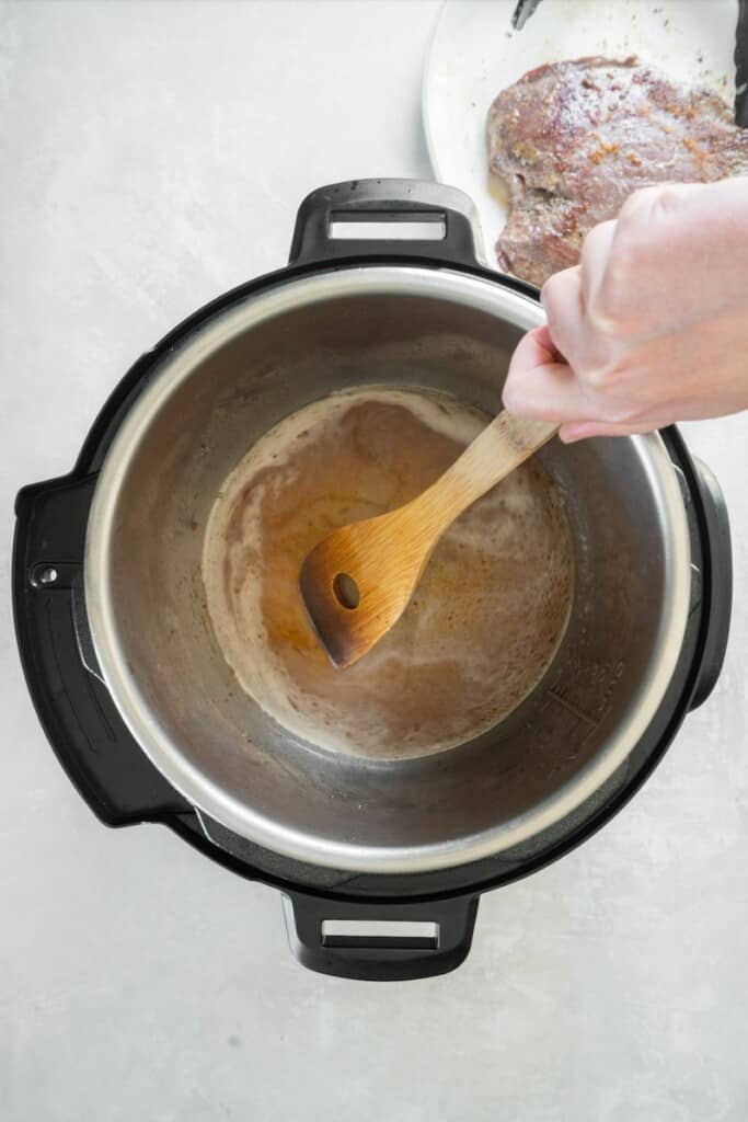 Deglazing an instant pot after searing a flank steak.