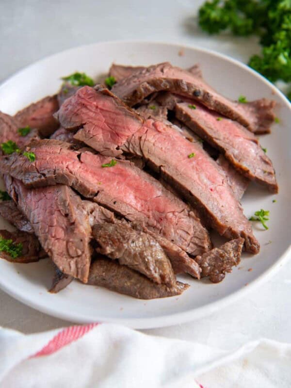 Slices of flank steak on a white plate.