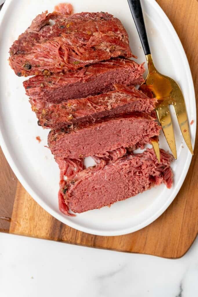 Sliced corned beef on a white plate.