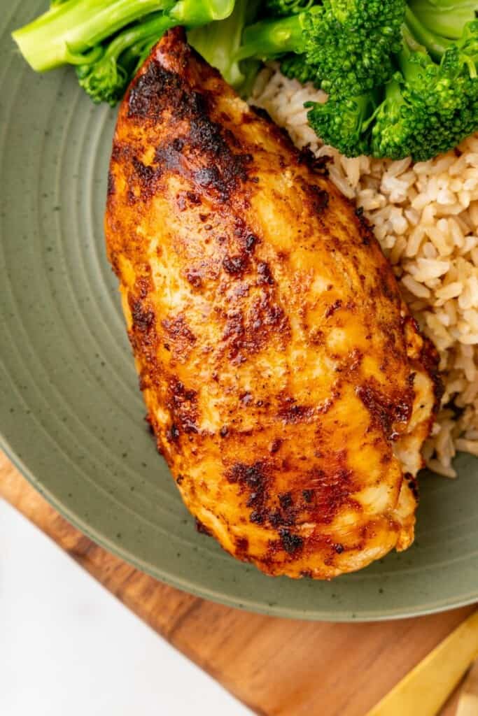 Closeup view of a chicken breast on a green plate.