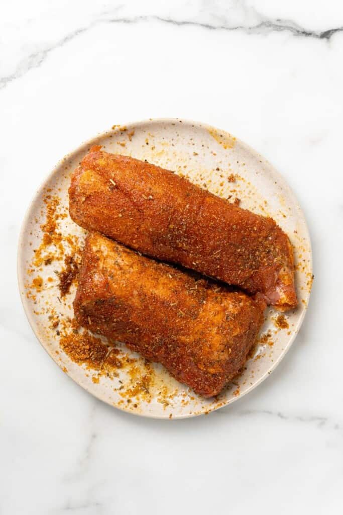 Pork Tenderloin with spice mix rubbed on to prepare it to be cooked.