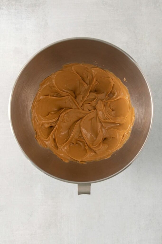 Peanut butter, butter, and vanilla in a mixing bowl mixed to make chocolate peanut butter balls.