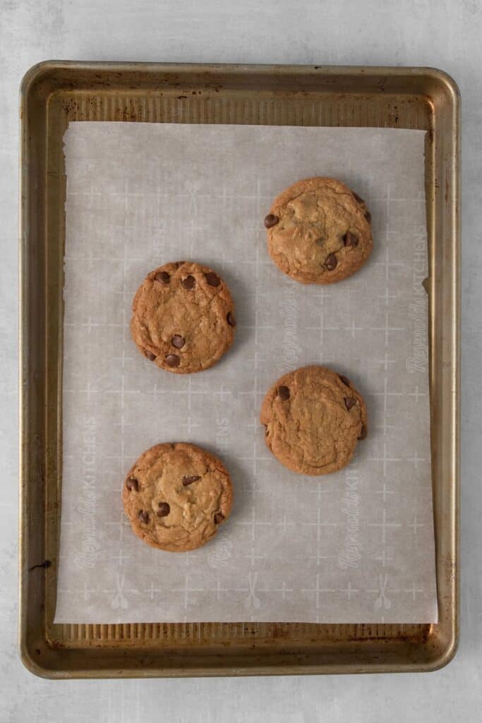 Baked chocolate chip cookie recipe with no butter on a baking sheet with parchment paper.
