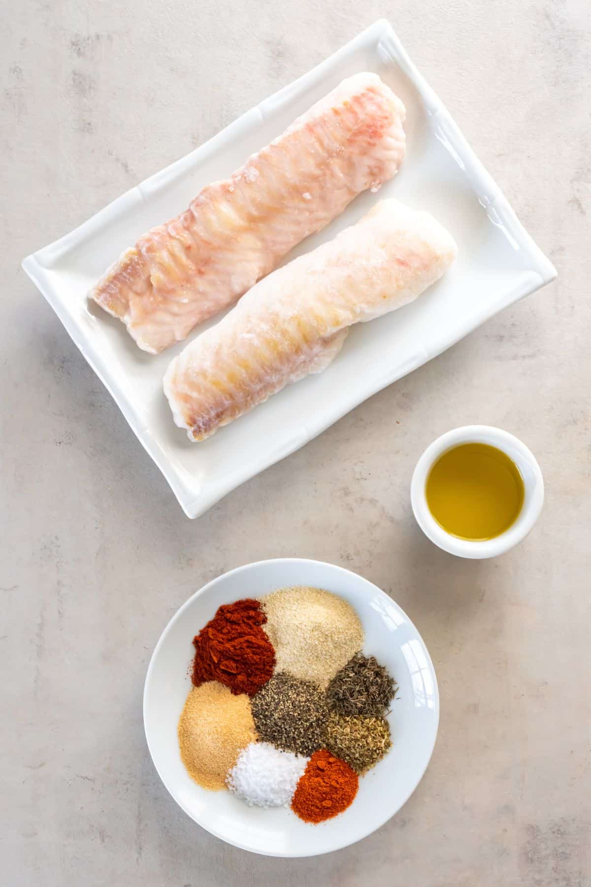 Ingredients needed to make frozen cod in the air fryer: frozen cod, oil, and blackened seasoning.