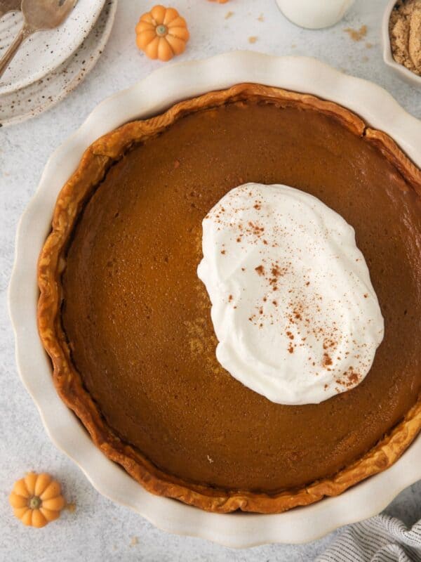 Pumpkin pie without evaporated milk with a big dollop of whipped cream on top.