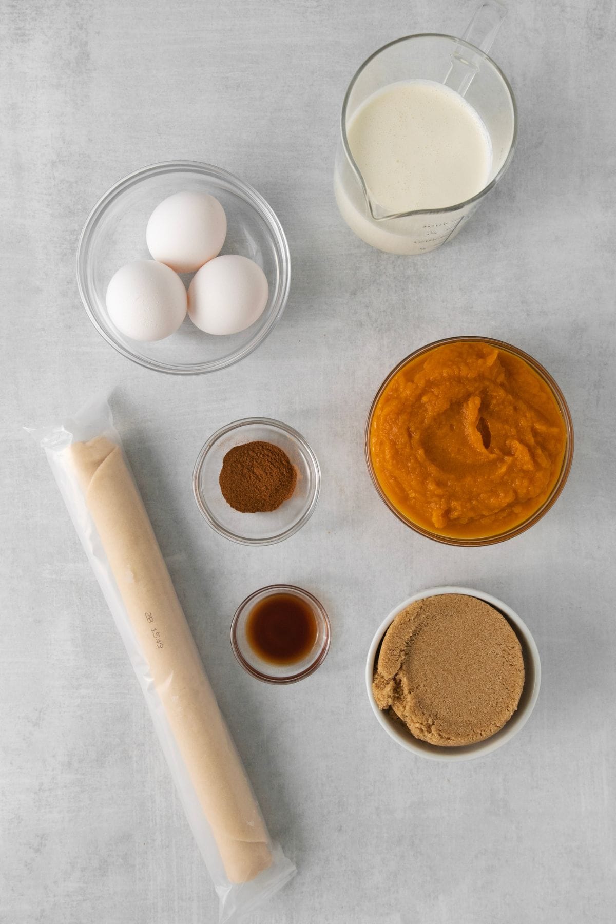 Ingredients needed to make a pumpkin pie without evaporated milk or condensed milk: pie crust, pumpkin puree, heavy cream, brown sugar, eggs, pumpkin pie spice, and vanilla extract.