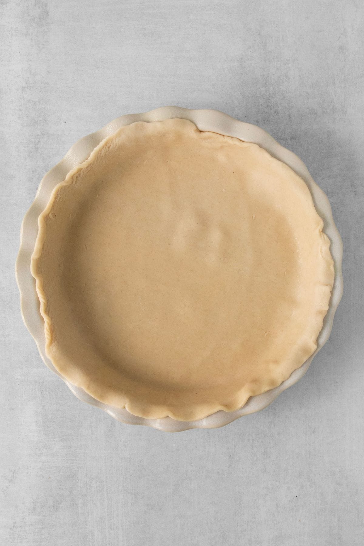 Pie crust pressed into a pie plate ready to be par-baked.
