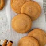 Snickerdoodles with Brown Butter on parchment paper with cinnamon sticks