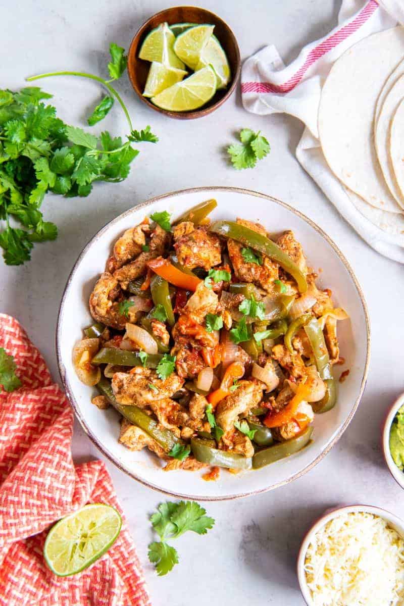Ingredients for chicken fajitas resting in a white bowl.