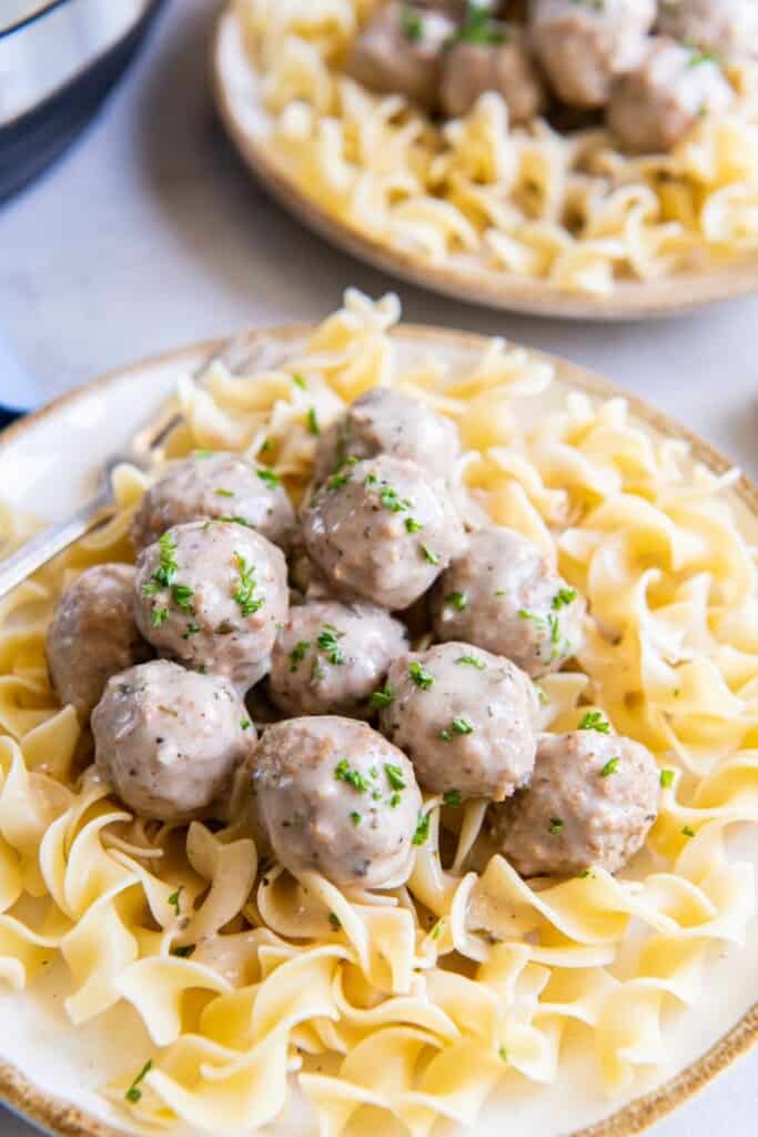 A Bowl of pasta and seasoned meatballs.