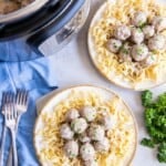 Two bowls filled with prepared meatballs and pasta.