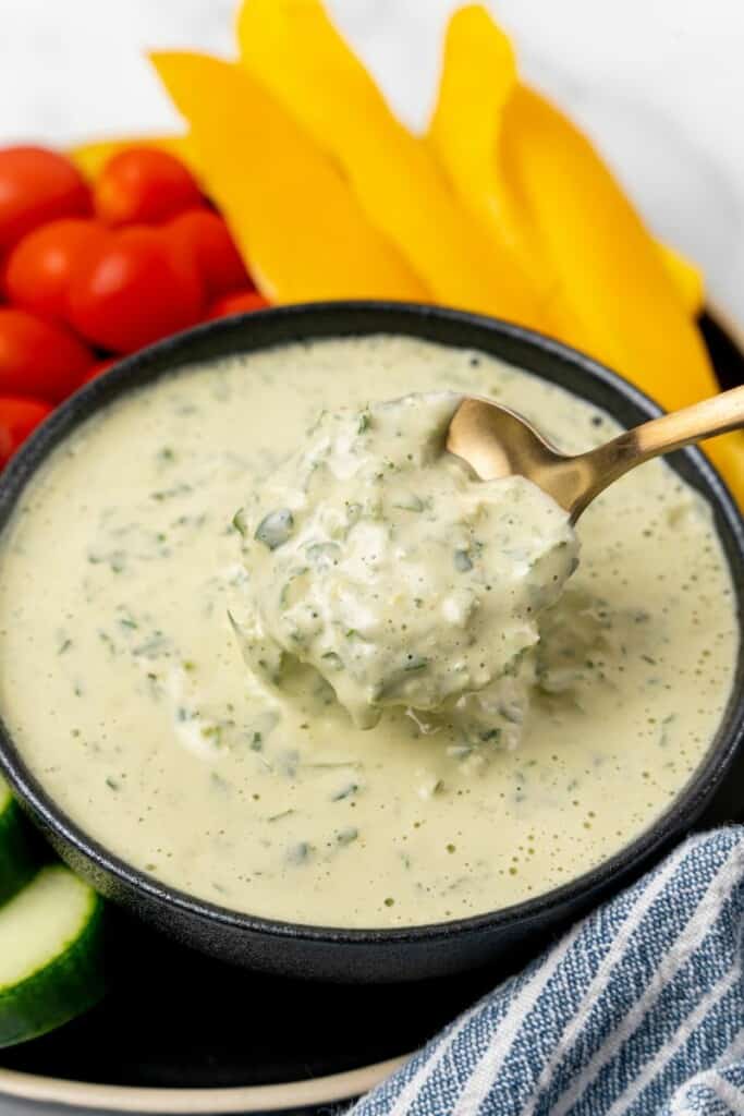 A spoon holding a bite of lemon herb tahini.