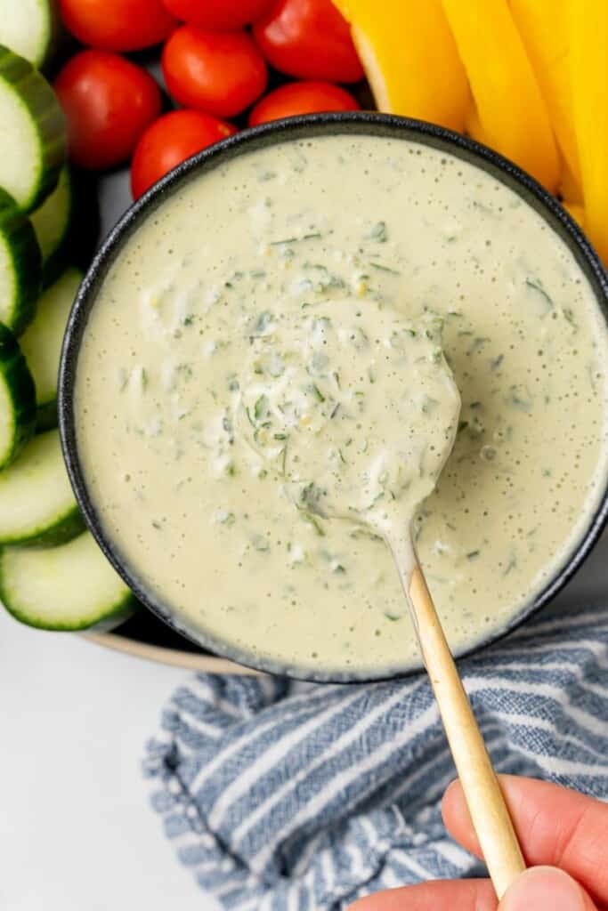 A spoon holding a bite of lemon herb tahini.