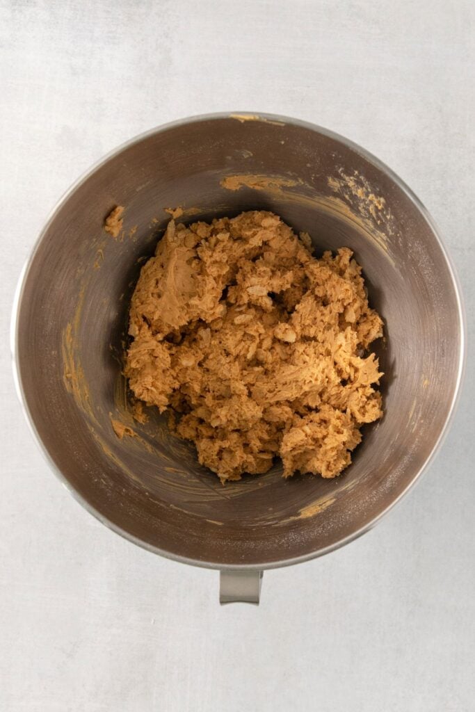 Powdered sugar and rice krispies mixed into the bowl to make peanut butter rice krispie balls.