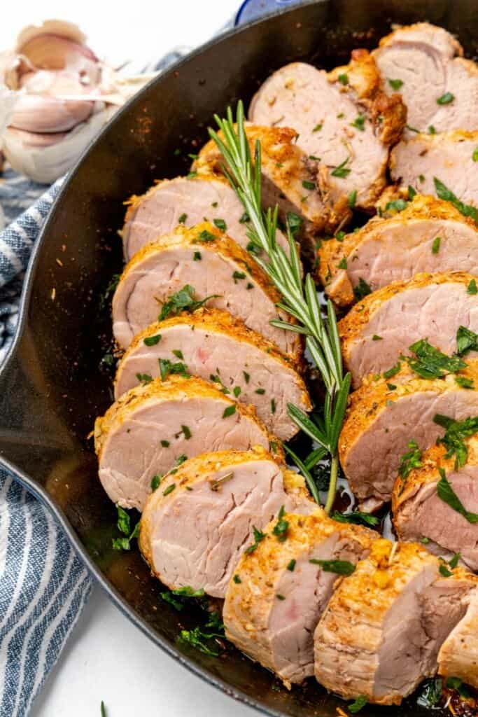 Slices of pork tenderloin prepared in a cast iron skillet.