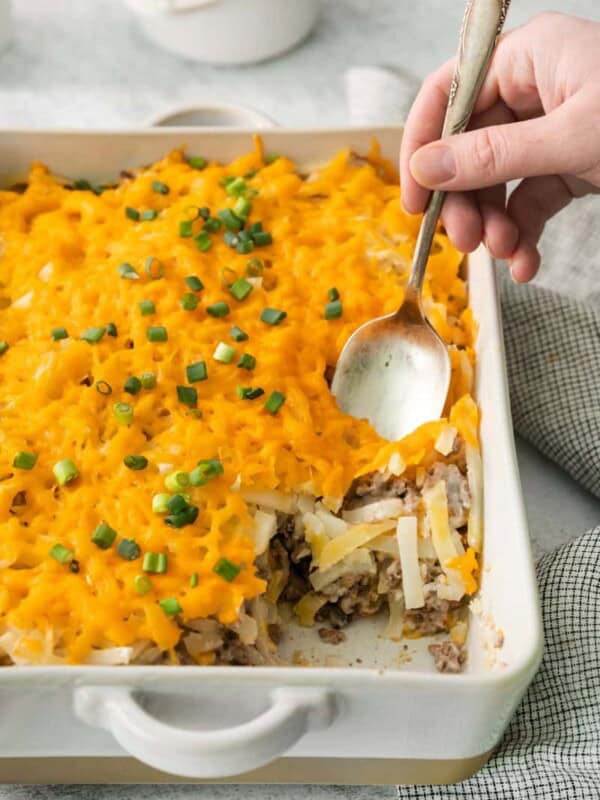 Hash brown casserole with a piece taken out and a spoon
