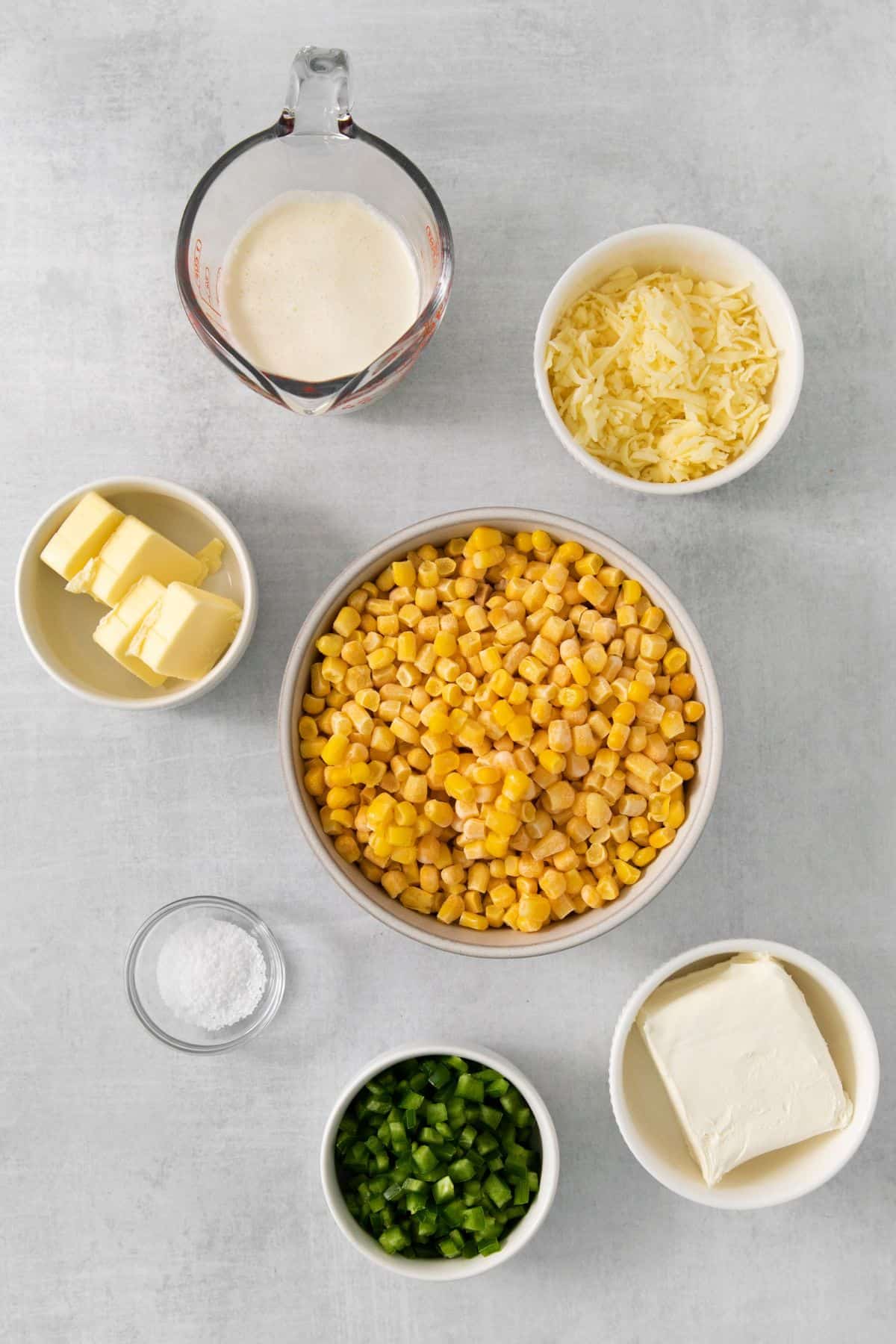 Ingredients needed to make jalapeno creamed corn: butter, corn, jalapenos, salt, cream cheese, heavy cream, and monterey jack cheese.