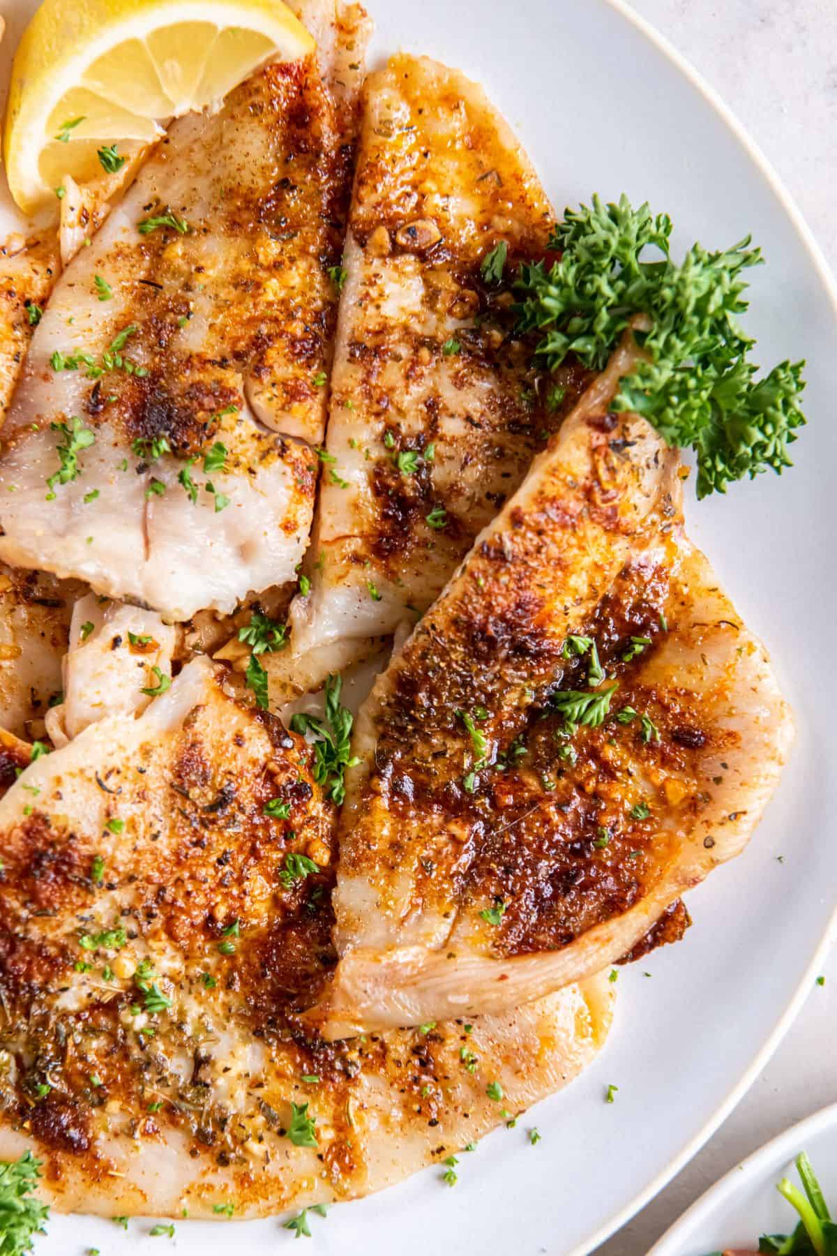 Air fryer flounder fillets on a white plate.