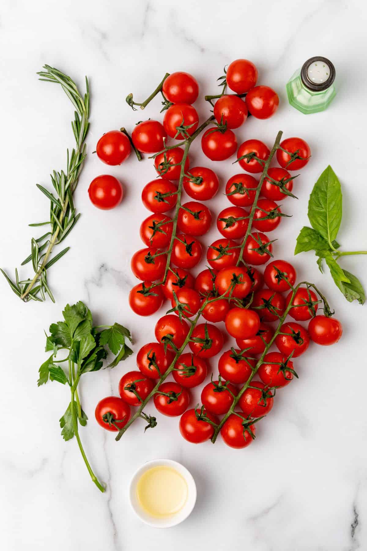 Ingredients needed to make tomatoes in the air fryer: tomatoes, oil, herbs, salt, and pepper.
