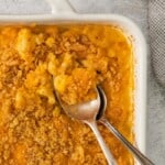 Closeup of macaroni casserole in a baking dish with 2 spoons