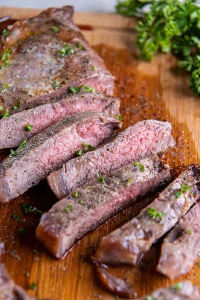 Close up of an air fryer NY strip steak cut up to see it medium rare on the inside.