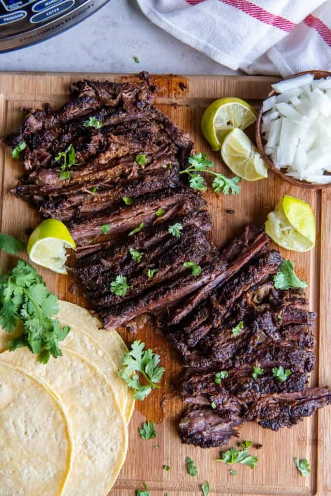 Slices of skirt steak on a wooden cutting board.
